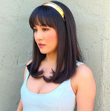 olivia rodrigo on the left with two long braided pigtails and constance wu on the right with brown straight hair and a gold headband